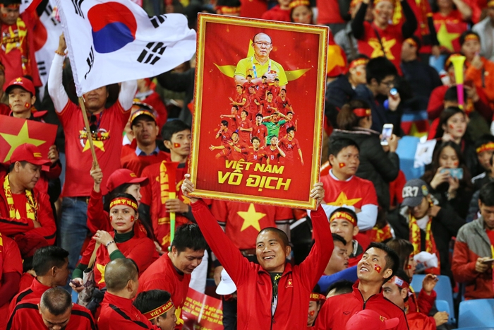 Vietnamese soccer fans on Dec. 15 root for their national team while waving the Vietnamese and Korean flags as well as a sign featuring Vietnam coach Park Hang-seo. Host Vietnam won the second leg of the 2018 AFF Suzuki Cup final versus Malaysia at My Dinh National Stadium in Hanoi. (Yonhap)